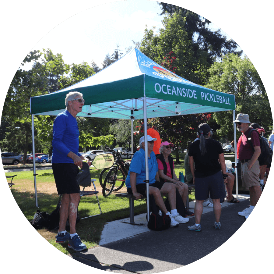 Oceanside Pickleball tent and players resting